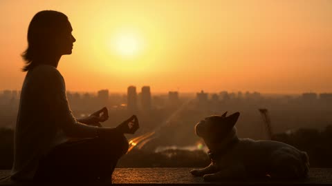 Woman meditating with her dog in the sunset