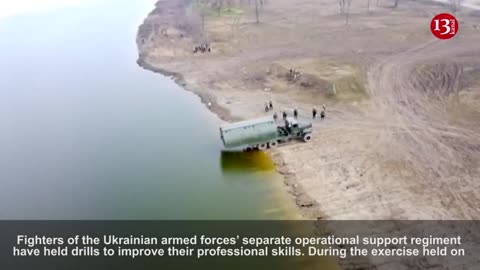 Ukrainian army preparing for battle by transporting heavy artillery across river via pontoon bridge