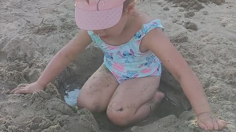 Baby girl loves to play on the sea