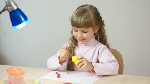 Baby girl paint the wooden figure toy. Fine Art How lesson