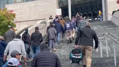 Seattle police and firefighters walking up the stairs of Seattle City Hall to turn in their boots