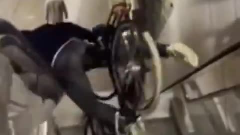 Dude Attempts to Ride His Bicycle Down An Escalator