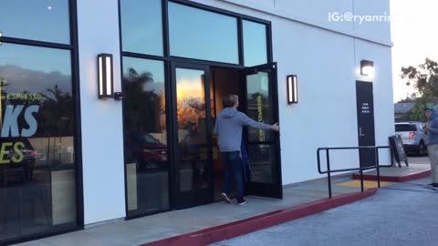 Guy walks into store and comes out in blue wetsuit