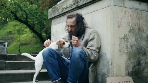 A Homeless Man Hugging a Dog