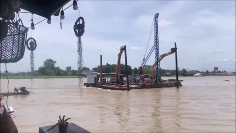 Tractors are being transported on a boat on the Chao Phraya River, Koh Kret, Thailand