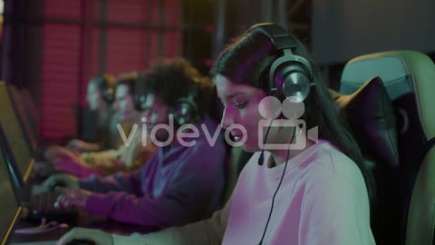 Side View Of A Cybersport Female Gamer Playing Video Games With Her Friends In A Gaming Club