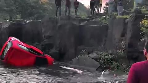 Parked car rolls over waterfall