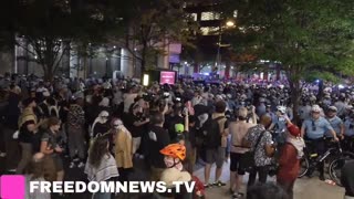 Pro-Palestine Protesters link arms and push against the police line outside of the Debate