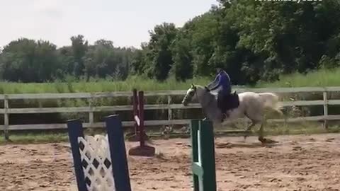 Girl in purple rides horse falls forward