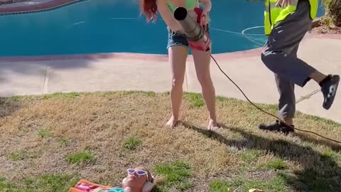 His reaction when the girl's towel blows off