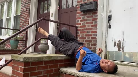 Luodong Massages Himself On The Front Steps