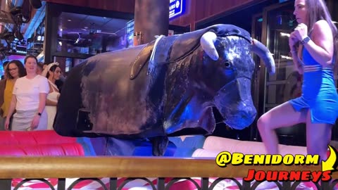 Beautiful Girl in Blue Dress Riding on a Mechanical Bull in Benidorm _ Bull Riding in 4K