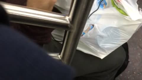 Person on subway train eating skippy peanut butter with their finger