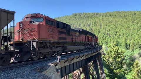 Solid EMD SD70ACe lineup up Mullan Pass. 3 BNSF, 4 MRL, then 1 BNSF on the rear.