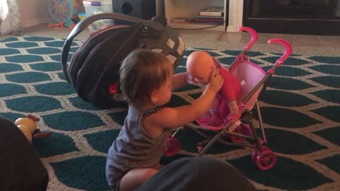 Little toddler plays with her doll