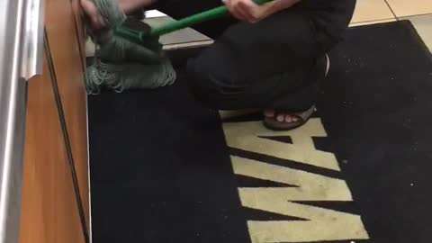 Fast Food Worker Uses Mop to Clean Benches