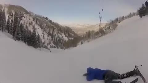 Yellow and blue crisscrossing skiers crash together on snow