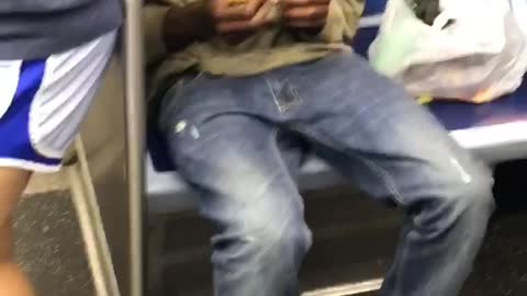 Guy blue shoes green shirt rolling blunt subway