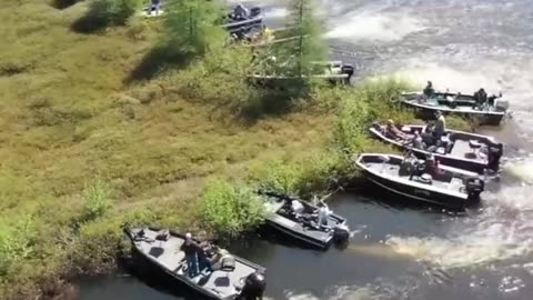 BOAT OWNERS MOVING A LARGE FLOATING ISLAND OUT OF THE WAY ON WISCONSIN’S LAKE CHIPPEWA