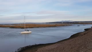 A lovely boat on a calm river . On a windy day. Coastal