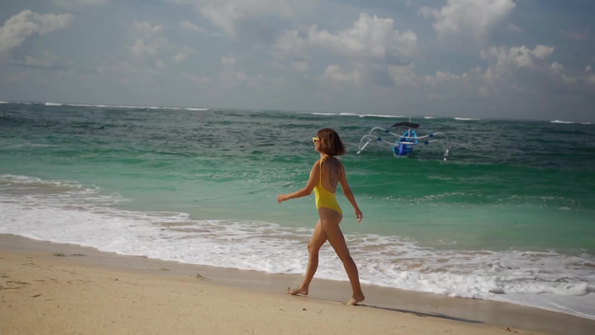 A YELLOW HOT BIKINI WOMEN WALKING ON SHORE