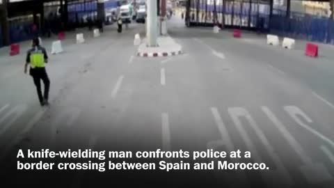 Spanish police throw traffic barrier at knife-wielding man