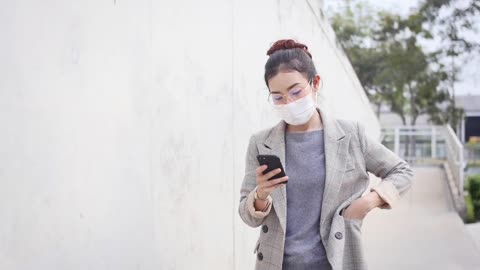 a woman wears a mask while walking