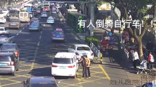 Cyclist With Toy Gun Rides Backwards In Busy Traffic