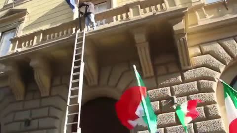 The people take down the EU flag in Rome and replace it with the Italian one.