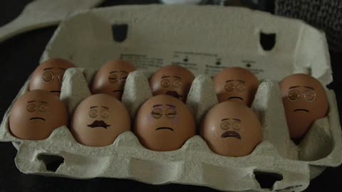 Man making eggs with faces on them