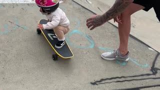 Young Girls Showcases Skateboard Skill with Dad's Help