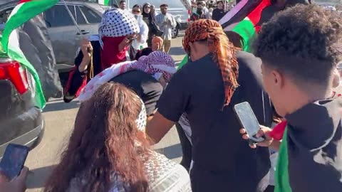 A woman waving an Israeli flag in San Diego is mobbed by a group of pro-Palestine protesters.