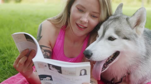 A Woman Reading a Book with Her Dog