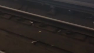 Baby shoes and wrist watch on a subway train track