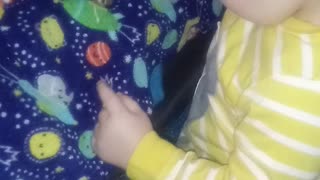 Sweet baby hugs the animals on his blanket