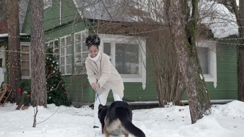 My mom plays with the dog in the snow