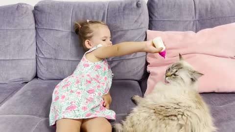 Cute_Baby_Girl_Feeding_a_Cat_From_a_Bottle