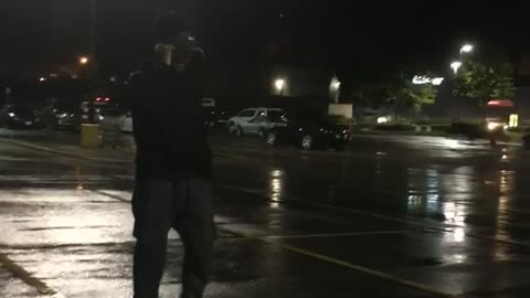 Guy black sweater on phone throws phone on floor parking lot