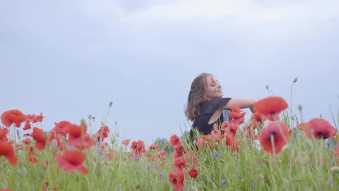 beautiful girl dancing in a poppy's field