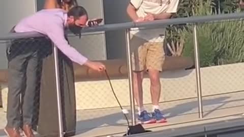 Things get a little sketchy when woman tries to retrieve her hat over the railing of a building.