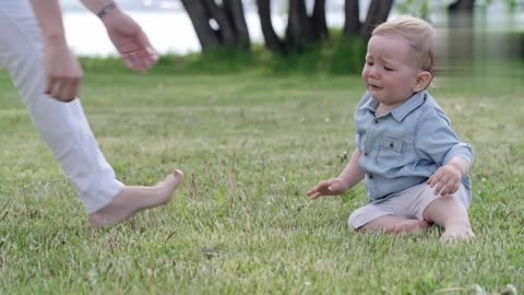 The baby is walking with his mother for the first time.