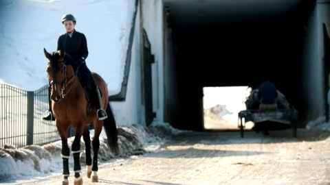 Riding a horse - woman rider is starting horseback riding