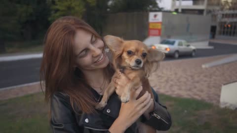 beautiful stylish red haired young woman in a leather jacket with dog