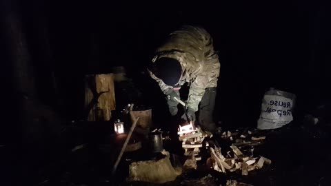 Making and lighting a campfire under a tarp. Woodland wildcamping