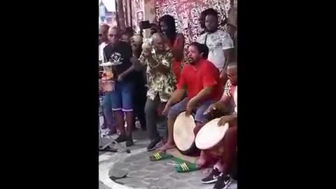 femme africaine qui danse avec du tambour dans la rue