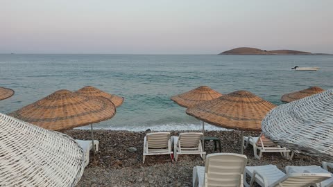 video lies of beach chairs sheded by rattan umbrell on the shore of beach