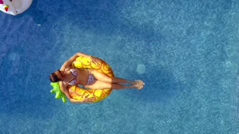 A young woman seen from above on a pineapple.