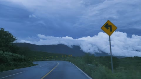 Going down a curved highway down a mountain,Lake surrounded by dry grass in the savanna