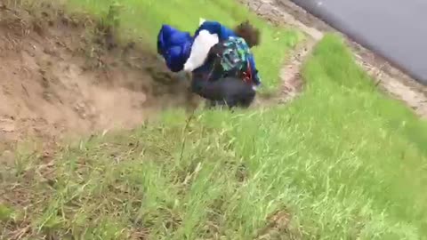 Man in blue runs down hill falls and rolls