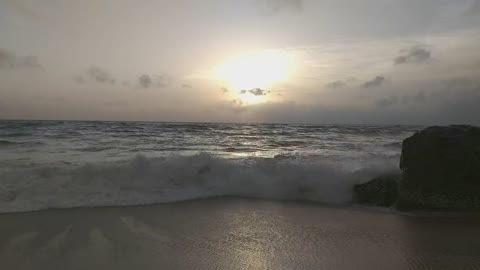 Sea Waves Rushing To Shore With View Of Sunset